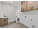 Functional laundry room features a utility sink, wood cabinets, and tile flooring at 61 Newcastle Sw St, Atlanta, GA 30314