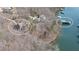 Aerial view showcasing the waterfront home and private dock on the tranquil lake setting amid a treed lot at 6880 Nantucket Cv, Cumming, GA 30041