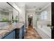 Elegant bathroom with dual sinks, granite countertops, soaking tub, and glass-enclosed shower at 6880 Nantucket Cv, Cumming, GA 30041
