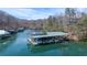 Waterfront property featuring a covered dock, boat lifts, and space for multiple boats; scenic wooded surroundings at 6880 Nantucket Cv, Cumming, GA 30041