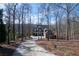 Secluded home on a wooded lot with mature trees, features a long driveway leading to the property at 6880 Nantucket Cv, Cumming, GA 30041