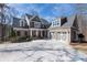 Beautiful brick home featuring a spacious driveway and a charming three-car garage with decorative doors at 6880 Nantucket Cv, Cumming, GA 30041