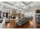 Spacious living room with stone fireplace, wood floors, coffered ceiling and open floor plan into the kitchen at 6880 Nantucket Cv, Cumming, GA 30041