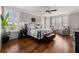 Cozy primary bedroom featuring wood floors, ceiling fan, and views of the surrounding wooded landscape at 6880 Nantucket Cv, Cumming, GA 30041