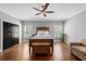 This primary bedroom features wood floors, a ceiling fan and plenty of natural light from two large windows at 6880 Nantucket Cv, Cumming, GA 30041