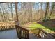 Backyard view from wooden deck showing wooded area, stone steps and small lawn at 1190 Saint Ives Ct, Suwanee, GA 30024