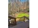 Backyard view from wooden deck showing wooded area, stone steps and small lawn at 1190 Saint Ives Ct, Suwanee, GA 30024
