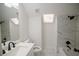 Modern bathroom featuring a skylight, marble-look tile, and black fixtures at 1190 Saint Ives Ct, Suwanee, GA 30024
