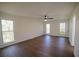 Spacious bedroom features hardwood floors, white walls, a ceiling fan and natural light at 1190 Saint Ives Ct, Suwanee, GA 30024
