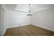 Dining room with modern light fixture, chair rail, tray ceiling, and hardwood floors at 1190 Saint Ives Ct, Suwanee, GA 30024