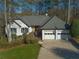 Attractive home featuring a white painted facade, black shutters, and an attached two-car garage at 1190 Saint Ives Ct, Suwanee, GA 30024