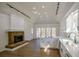 Bright kitchen boasts stone fireplace, white cabinets, stainless steel appliances, and hardwood floors at 1190 Saint Ives Ct, Suwanee, GA 30024