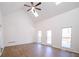 Bright living room featuring vaulted ceilings, three windows, a fireplace, and wood flooring at 1190 Saint Ives Ct, Suwanee, GA 30024