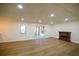 Open living room boasts modern flooring, recessed lighting, a fireplace, and access to a screened porch at 1190 Saint Ives Ct, Suwanee, GA 30024