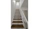 Staircase with stained wood treads, white risers, and a white handrail at 1190 Saint Ives Ct, Suwanee, GA 30024