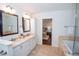 Elegant bathroom featuring dual sinks, marble counters, tile floors, and a glimpse of the connecting bedroom at 1251 Cumberland Ne Rd, Atlanta, GA 30306
