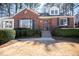 Charming brick home showcasing a manicured lawn, dark shutters, and lovely landscaping at 1251 Cumberland Ne Rd, Atlanta, GA 30306
