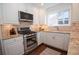 Close up of the kitchen, featuring stainless steel oven and gas cooktop, granite counters and light backsplash at 1251 Cumberland Ne Rd, Atlanta, GA 30306