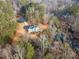 Stunning aerial view of the house surrounded by lush greenery and a serene creek at 241 Nacoochee Dr, Woodstock, GA 30188