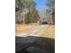 View of the long driveway lined with white fence and brick pillars for added elegance at 241 Nacoochee Dr, Woodstock, GA 30188