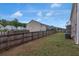 Fenced backyard offering privacy, featuring a spacious green lawn, a brown brick house, and lush green trees at 436 Vermeer Ct, Locust Grove, GA 30248