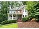 Inviting two-story home with brick and gray siding, a covered front porch, and mature landscaping at 2690 Valvedere Dr, Brookhaven, GA 30319
