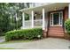 Charming front porch with brick steps, white railings, ceiling fan, and lush landscaping at 2690 Valvedere Dr, Brookhaven, GA 30319