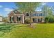 Two story home showcasing a well-manicured lawn, stone accents, and a charming covered porch area at 6350 Bridge Brook Ovlk, Cumming, GA 30028