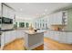 Kitchen boasts an island, granite countertops, stainless steel appliances, and custom white cabinets at 6350 Bridge Brook Ovlk, Cumming, GA 30028