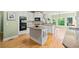 View of the kitchen with an island, granite countertops, white cabinets, and stainless steel appliances at 6350 Bridge Brook Ovlk, Cumming, GA 30028