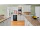 Open kitchen with granite counters, stainless steel dishwasher, and a view of the living room fireplace at 6350 Bridge Brook Ovlk, Cumming, GA 30028
