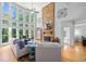 Bright living room featuring a stone fireplace and a wall of large windows offering abundant natural light at 6350 Bridge Brook Ovlk, Cumming, GA 30028