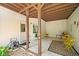 Covered patio with stone and concrete floor, overhead beams and patio furniture at 6350 Bridge Brook Ovlk, Cumming, GA 30028