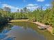 Scenic pond with a wooden deck overlooking the water, surrounded by lush greenery and trees at 6350 Bridge Brook Ovlk, Cumming, GA 30028