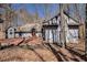 Exterior view of house featuring attached brick driveway and a wooded area at 6575 Roundhill Ct, Cumming, GA 30040