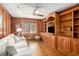 Cozy office with wood paneling, built-in bookcases, and a comfortable sofa at 6575 Roundhill Ct, Cumming, GA 30040