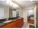 Well-lit bathroom with double vanity, granite countertops, and a separate office space at 855 Peachtree Ne St # 1911, Atlanta, GA 30308