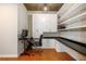 A well-lit home office with built-in cabinets, floating shelves, desk and an adjustable executive style chair at 855 Peachtree Ne St # 1911, Atlanta, GA 30308