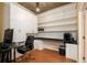 A spacious home office features storage cabinets, built-in shelving and desk area, illuminated by pendant lighting at 855 Peachtree Ne St # 1911, Atlanta, GA 30308