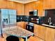 Well lit kitchen with wood cabinets, stainless steel appliances, and black tile backsplash at 923 Peachtree Ne St # 1527, Atlanta, GA 30309