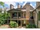 Back exterior of house featuring screened porch, deck area, and brick facade at 200 Rivermere Way, Sandy Springs, GA 30350