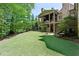 Manicured backyard with expansive grassy area and mature trees, perfect for outdoor activities at 200 Rivermere Way, Sandy Springs, GA 30350
