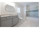 Bright bathroom features a gray vanity with light granite countertops and glass enclosed tub shower at 200 Rivermere Way, Sandy Springs, GA 30350