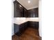 A beautiful butler's pantry featuring dark wood cabinetry, glass door uppers, and stone countertops at 200 Rivermere Way, Sandy Springs, GA 30350