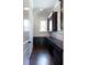 Hallway featuring a butlers pantry with dark wood cabinetry, drawers and an arched window at 200 Rivermere Way, Sandy Springs, GA 30350