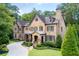 Impressive stone and wood exterior featuring a covered porch and manicured landscaping at 200 Rivermere Way, Sandy Springs, GA 30350