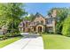 Stunning stone home with manicured lawn, circular drive, and mature trees exudes curb appeal at 200 Rivermere Way, Sandy Springs, GA 30350