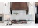Close-up of the gourmet gas range and custom backsplash in the kitchen at 200 Rivermere Way, Sandy Springs, GA 30350
