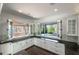 Spacious kitchen featuring white cabinets, bi-fold pass-through windows, and dark countertops at 200 Rivermere Way, Sandy Springs, GA 30350