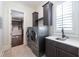 A modern laundry room with a gray front load washer and dryer and custom cabinets at 200 Rivermere Way, Sandy Springs, GA 30350